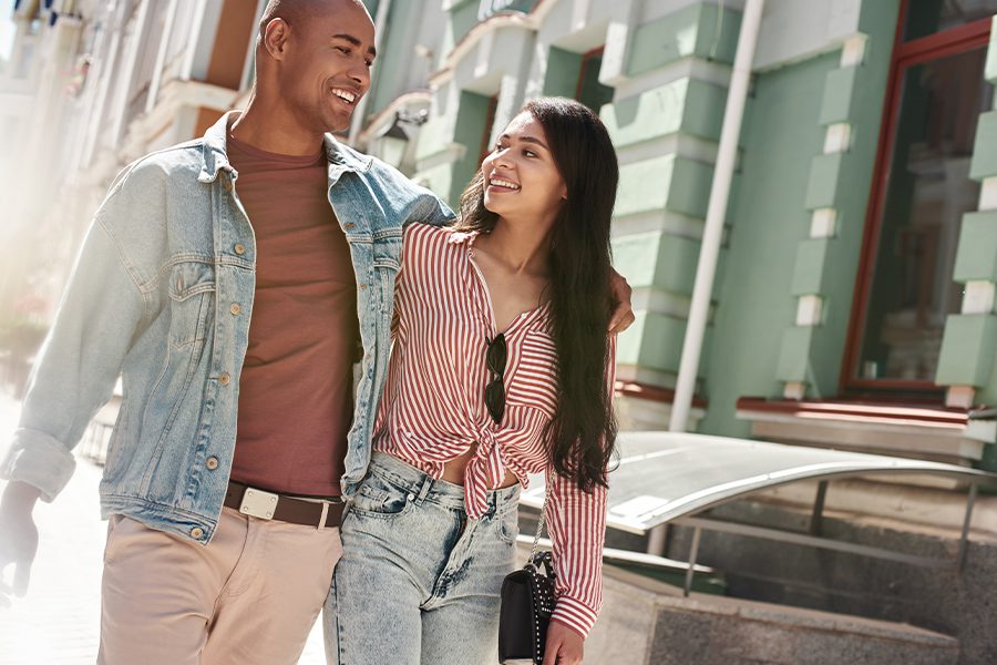 Contact - Happy Young Couple Walking Down a City Street on a Sunny Afternoon